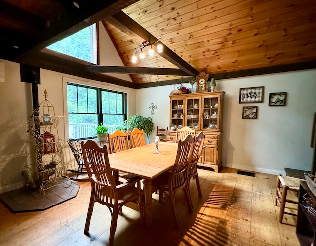 dining room featuring light wood-type flooring, vaulted ceiling with beams, and wood ceiling