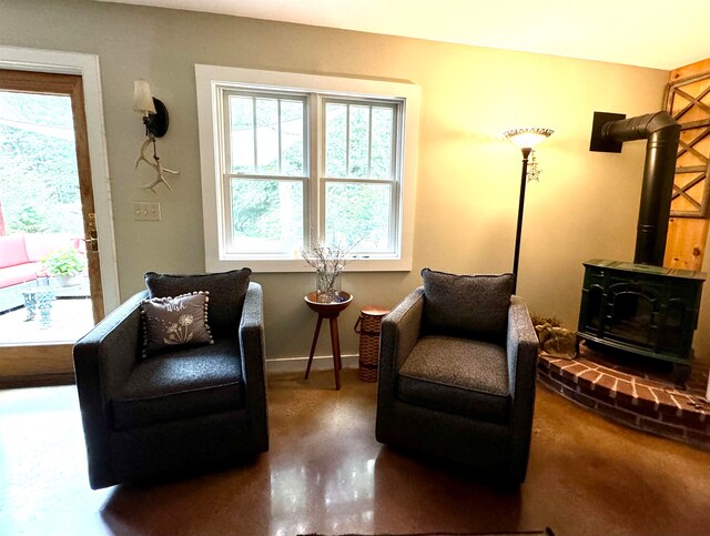 living area featuring concrete floors and a wood stove