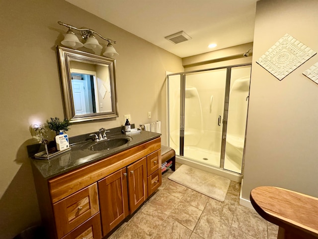 bathroom with a shower with shower door, tile patterned floors, and vanity