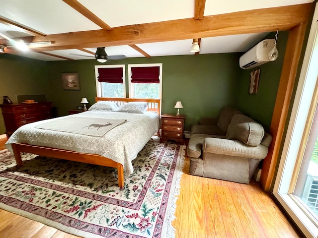 bedroom with beamed ceiling, an AC wall unit, ceiling fan, and hardwood / wood-style floors