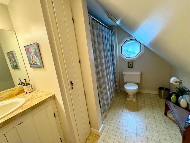 bathroom with vaulted ceiling, vanity, tile patterned floors, and toilet