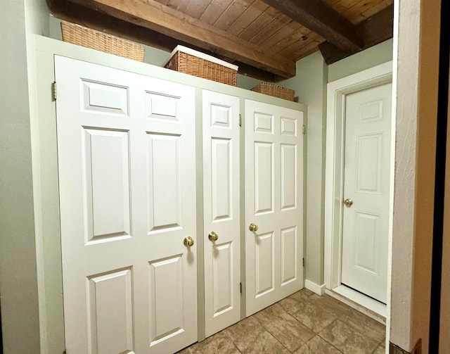 interior space featuring wood ceiling, light tile patterned floors, and beam ceiling