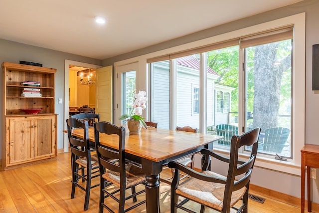 dining space featuring a notable chandelier and light hardwood / wood-style flooring