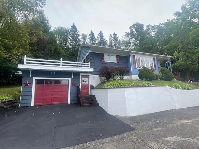 ranch-style home with aphalt driveway and an attached garage