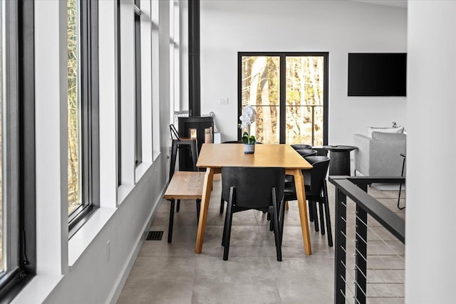 dining area featuring baseboards, visible vents, and finished concrete floors