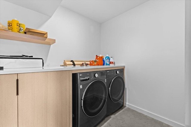 washroom with laundry area, washing machine and dryer, and baseboards