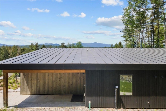 view of property exterior with a mountain view, metal roof, and a standing seam roof