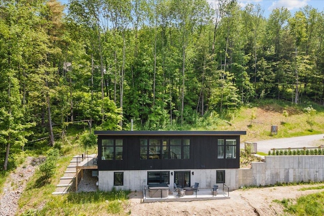 rear view of property with stairway and a patio area