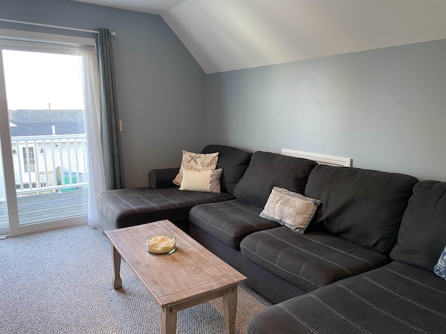 living area featuring a wealth of natural light, lofted ceiling, and carpet