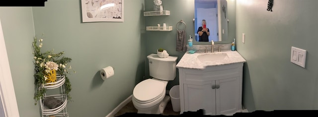 bathroom with baseboards, toilet, and vanity