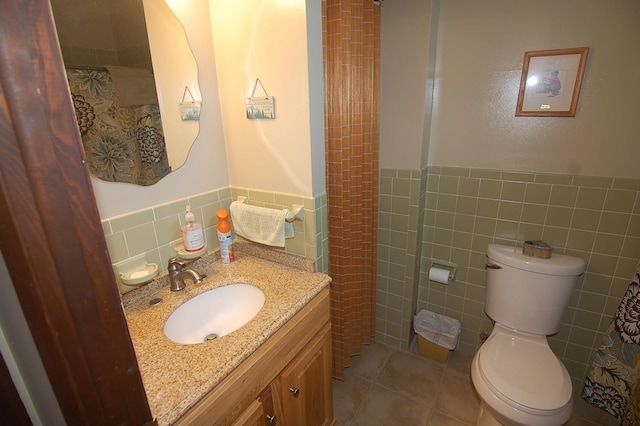 bathroom featuring toilet, tasteful backsplash, vanity, tile walls, and tile patterned floors