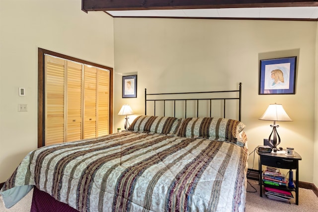 bedroom featuring carpet floors, vaulted ceiling with beams, and a closet