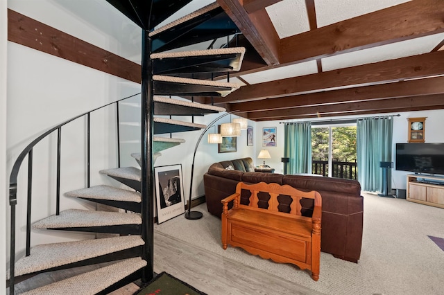 living room featuring beamed ceiling and light hardwood / wood-style flooring