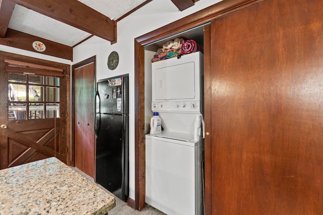 laundry area with stacked washer / drying machine and hardwood / wood-style floors