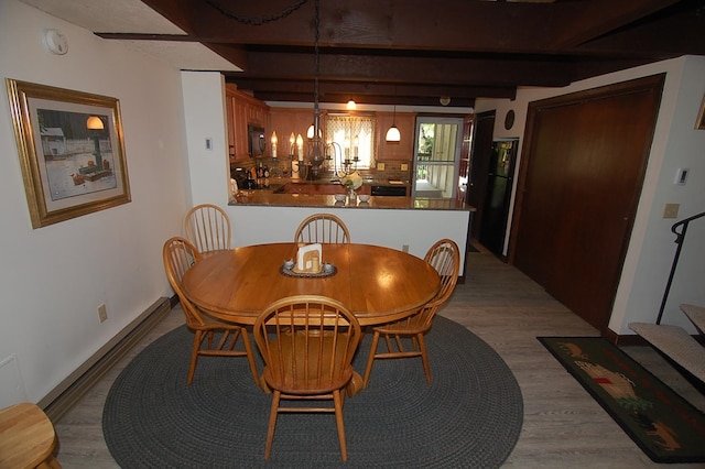 dining room featuring light hardwood / wood-style floors and beamed ceiling