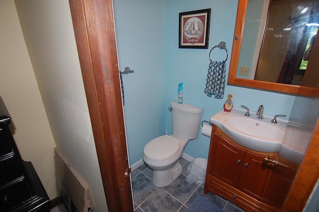 bathroom with toilet, vanity, and tile patterned floors