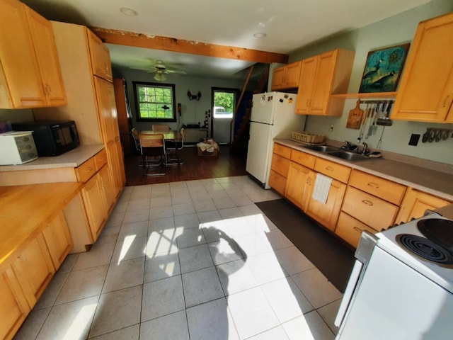 kitchen with light countertops, light brown cabinetry, light tile patterned flooring, a sink, and white appliances