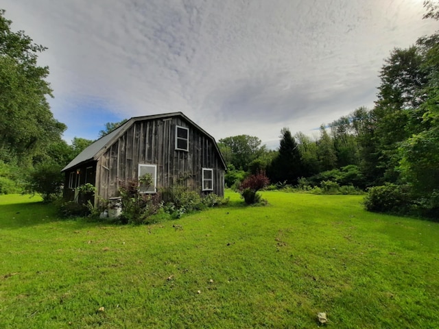 view of side of property with a barn, an outbuilding, a lawn, and a gambrel roof