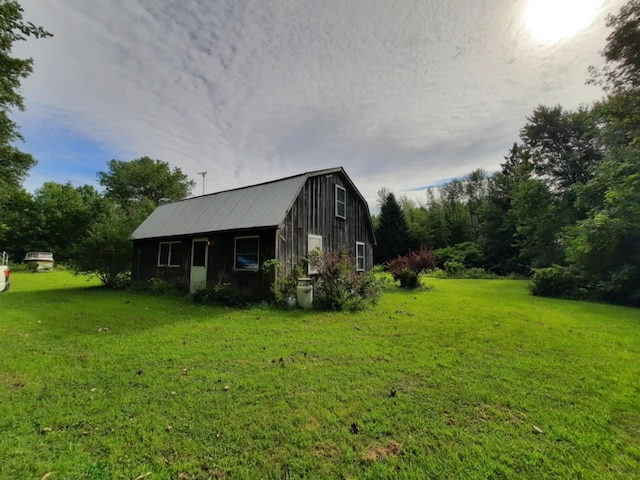 view of side of property with metal roof, a yard, and a gambrel roof