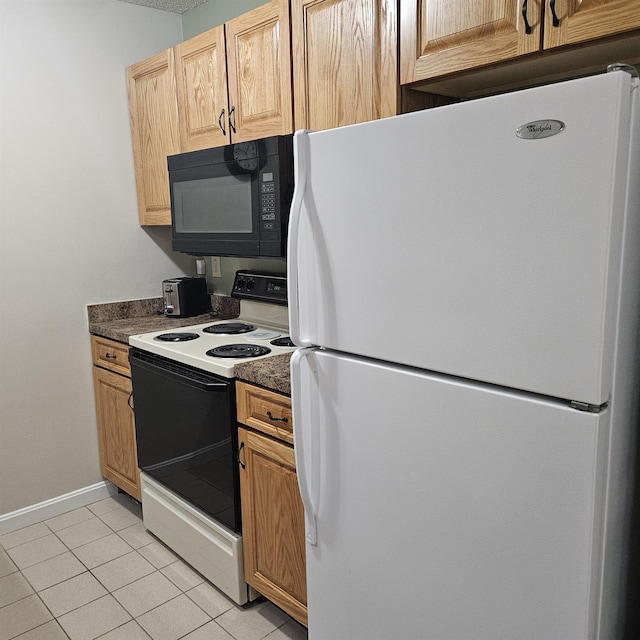 kitchen with dark countertops, light tile patterned floors, baseboards, and white appliances