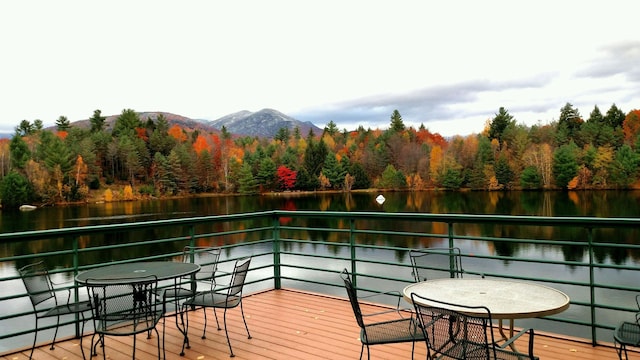 deck with a wooded view and a water and mountain view