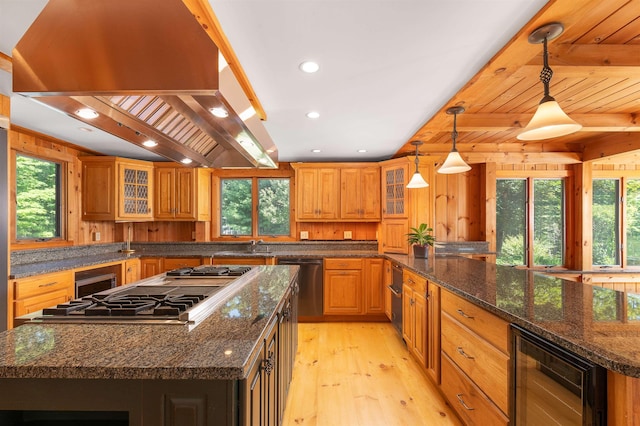 kitchen with a kitchen island, pendant lighting, island exhaust hood, stainless steel appliances, and beverage cooler