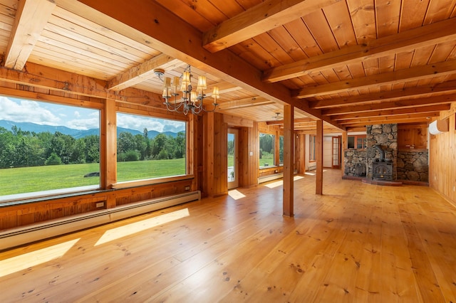 unfurnished living room featuring wood ceiling, a wood stove, baseboard heating, light wood-type flooring, and beamed ceiling