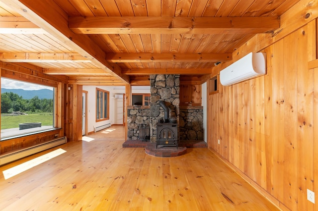 unfurnished living room featuring wood walls, a baseboard heating unit, an AC wall unit, and a wood stove