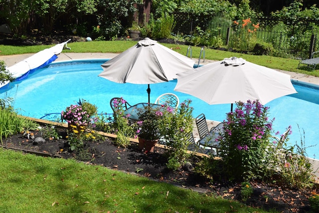 view of swimming pool with a yard