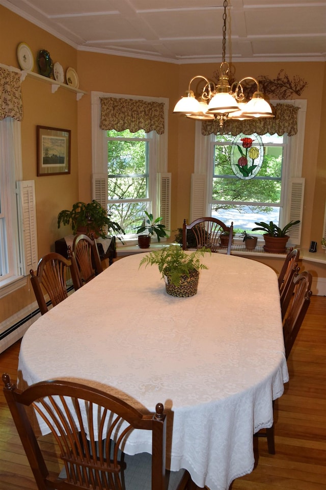 dining room featuring hardwood / wood-style flooring, crown molding, and a notable chandelier