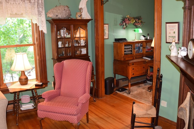 living area with hardwood / wood-style flooring and a baseboard radiator