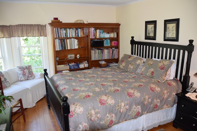 bedroom with ornamental molding and hardwood / wood-style floors