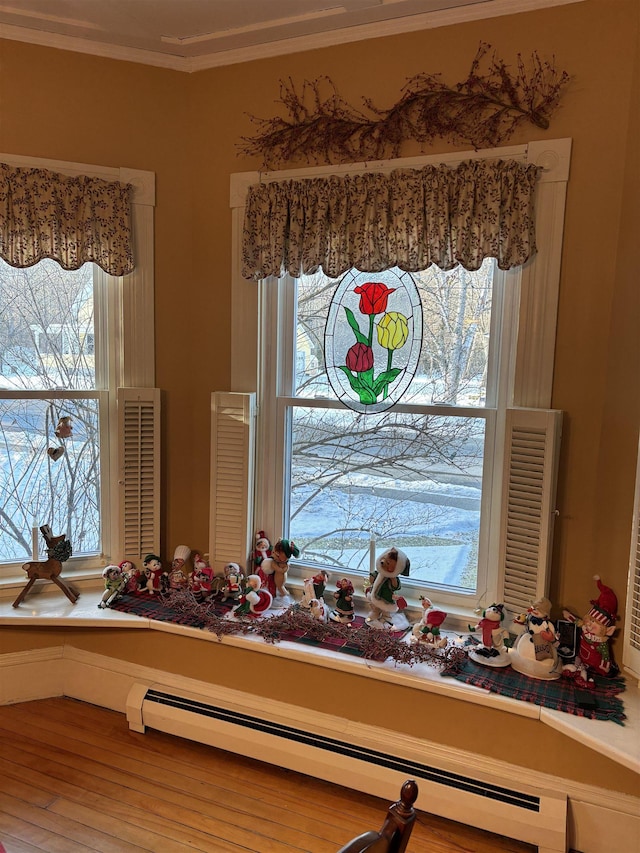 details featuring hardwood / wood-style flooring, ornamental molding, and a baseboard heating unit