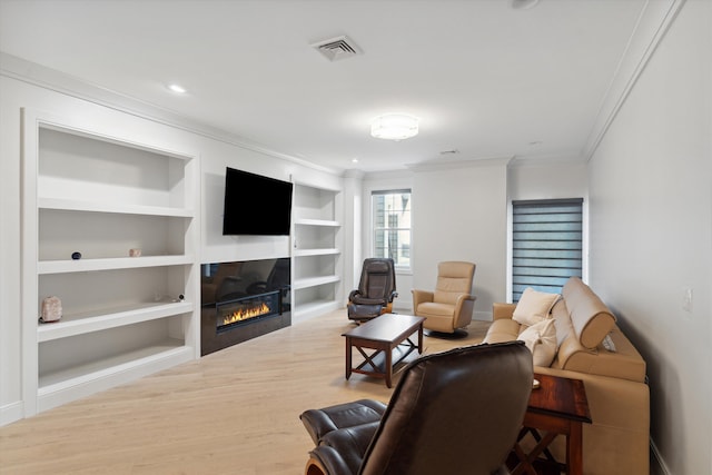 living room with built in shelves, ornamental molding, and hardwood / wood-style floors