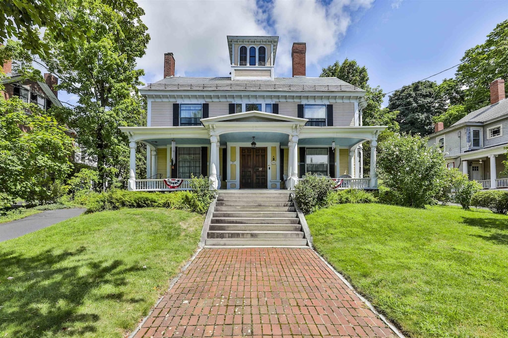 italianate-style house featuring a front lawn and covered porch