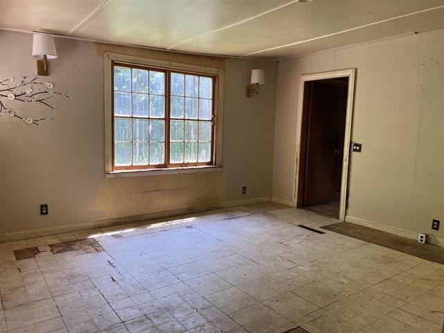 unfurnished room featuring baseboards and tile patterned floors