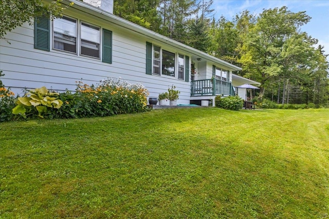 view of home's exterior with a lawn and a porch