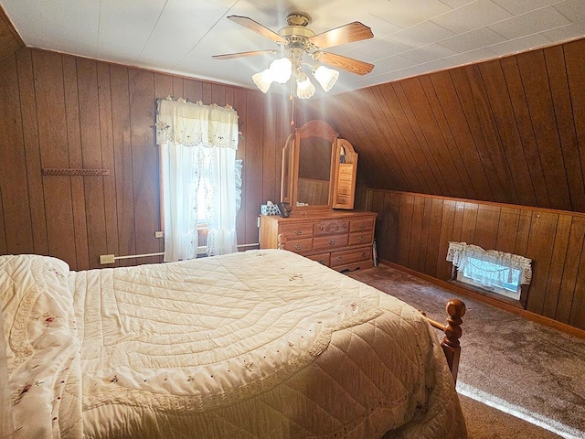 bedroom featuring lofted ceiling, wood walls, ceiling fan, and carpet flooring