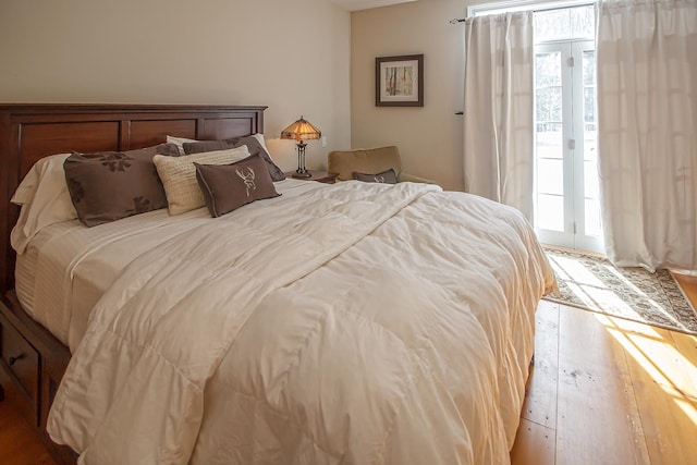 bedroom featuring light wood-type flooring and access to outside