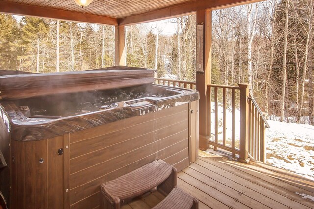 snow covered deck featuring a hot tub