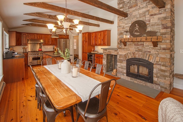 dining space with a baseboard heating unit, light wood-type flooring, a notable chandelier, vaulted ceiling with beams, and sink