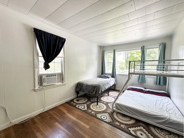 10 Hawthorne St, Plymouth, NH 03264 - bedroom with wood-type flooring, baseboards, cooling unit, and wood walls