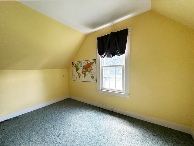 bonus room with lofted ceiling and carpet flooring