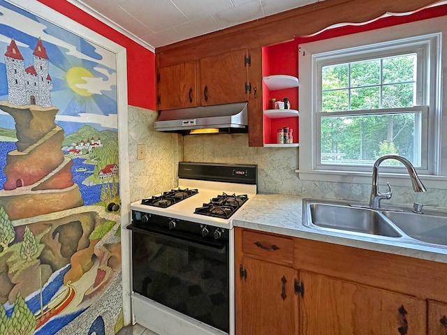 kitchen with white range with gas stovetop, decorative backsplash, sink, and extractor fan