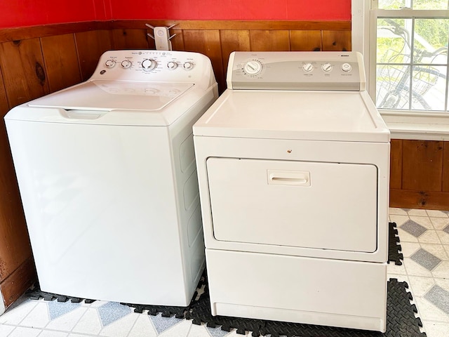 laundry area featuring wood walls and independent washer and dryer