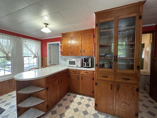 10 Hawthorne St, Plymouth, NH 03264 - kitchen featuring open shelves, white microwave, a peninsula, light countertops, and brown cabinetry