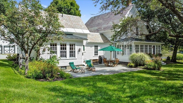 rear view of property with a yard and a patio