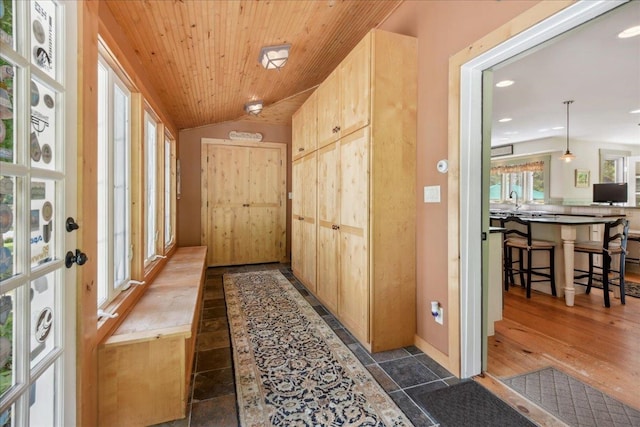 interior space with dark hardwood / wood-style floors, vaulted ceiling, wooden ceiling, and sink