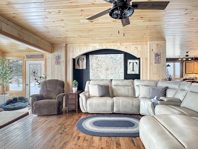 living room with a healthy amount of sunlight, wood ceiling, wooden walls, and wood finished floors