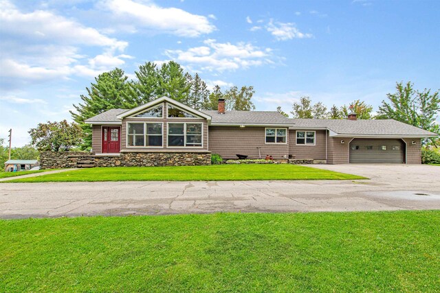 view of front of house featuring a garage, a mountain view, and a front lawn